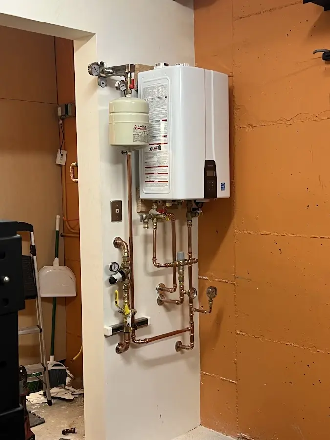 Plumbing technician inspecting water heater connections in Olive Branch